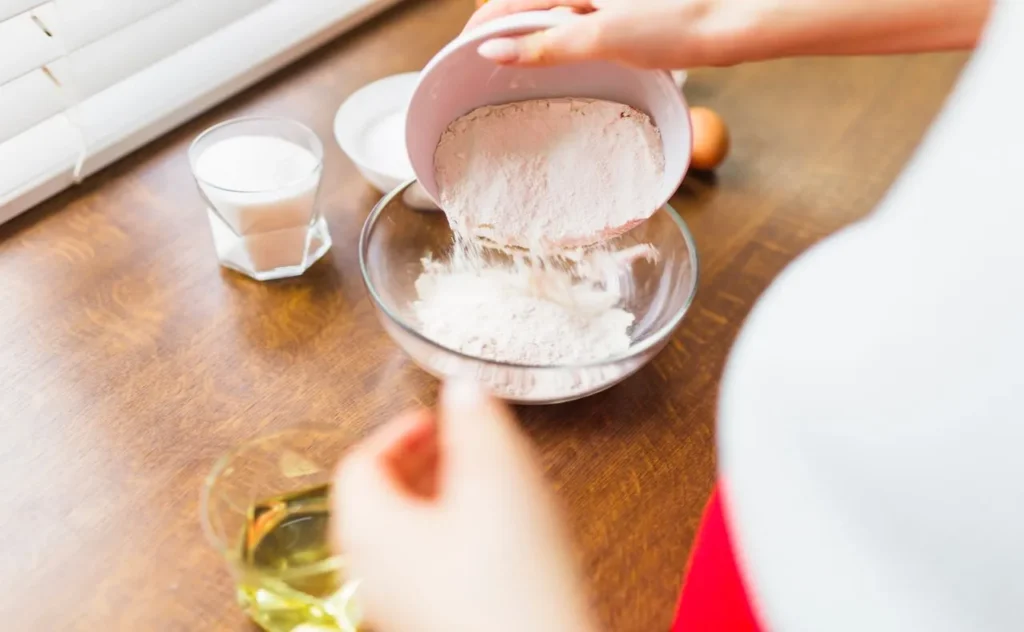 person filling bowl with-flour